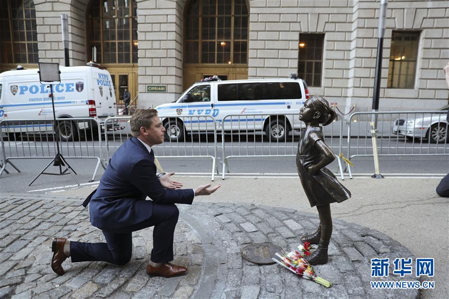 嫁给我吧 3月9日，一名男士在美国纽约华尔街铜牛对面的“无畏女孩”塑像旁留影。这座塑像由一家金融投资公司放置于此，呼吁企业给予女性平等的工作和晋升机会。记者 王迎/摄