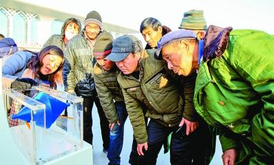 宁夏回族自治区文化科技卫生“三下乡”集中示范活动中，来自科技部门的工作人员(左一)在为群众讲解“锥体上滚”的操作。新华社发