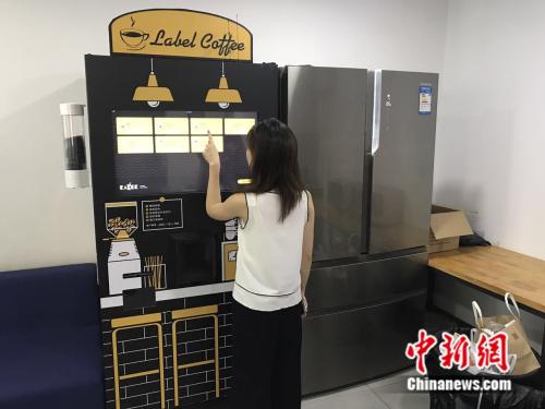 7月21日，三里屯SOHO内，一名白领正在使用自动咖啡售卖机。潘心怡 摄